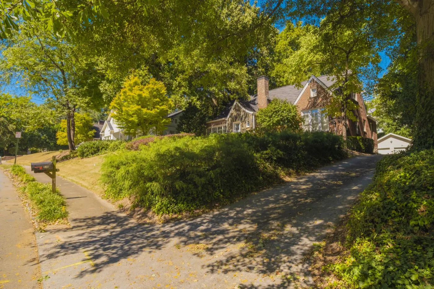 Brick house up a sloping, wooded lot