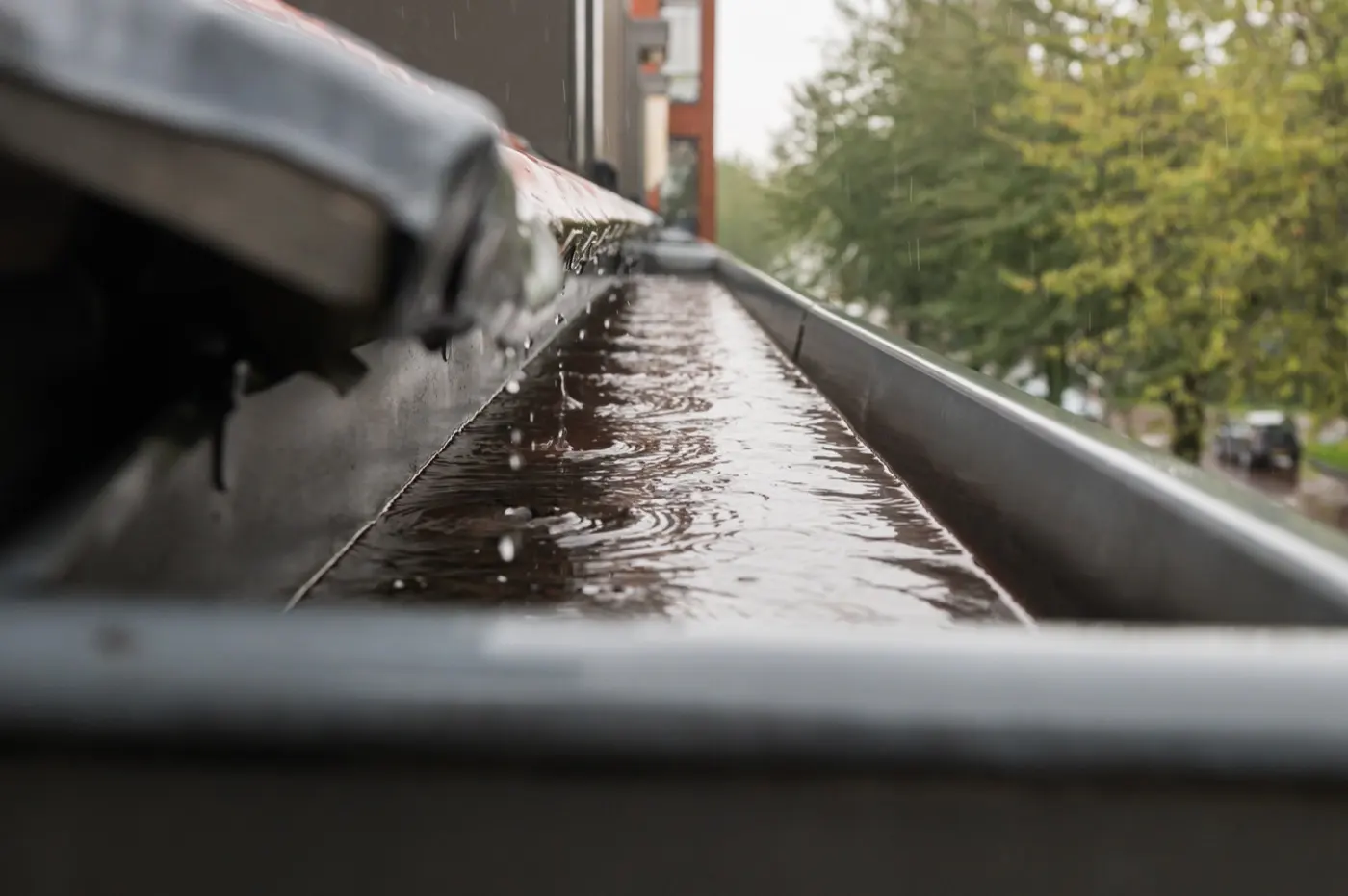 Roof gutter running full of rainwater