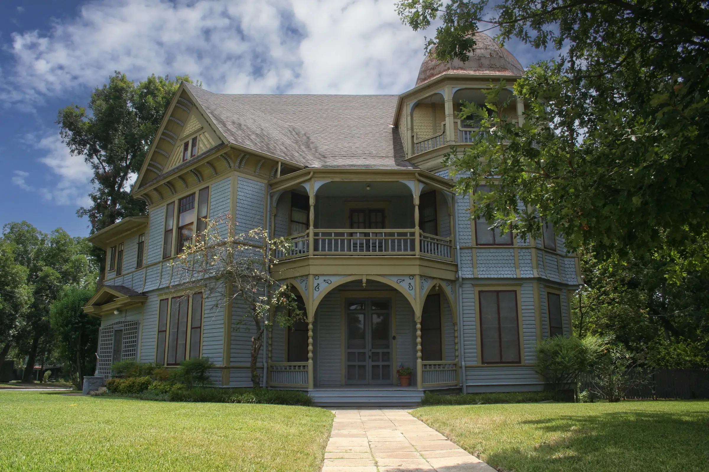 Historic two-story frame house in rural East Texas, its porch a few steps above the lawn