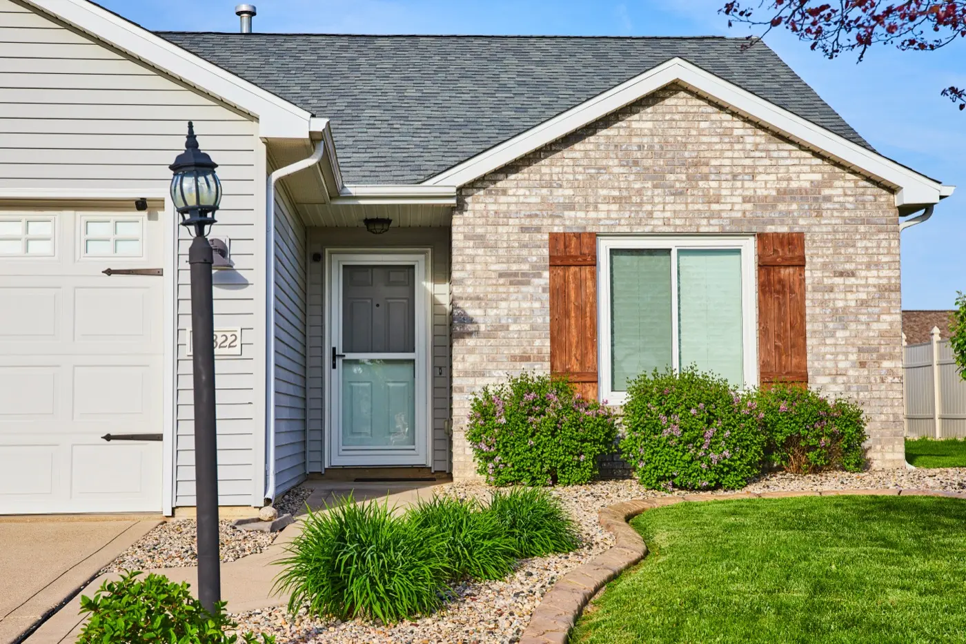 Newer single-story tan brick home with a garage