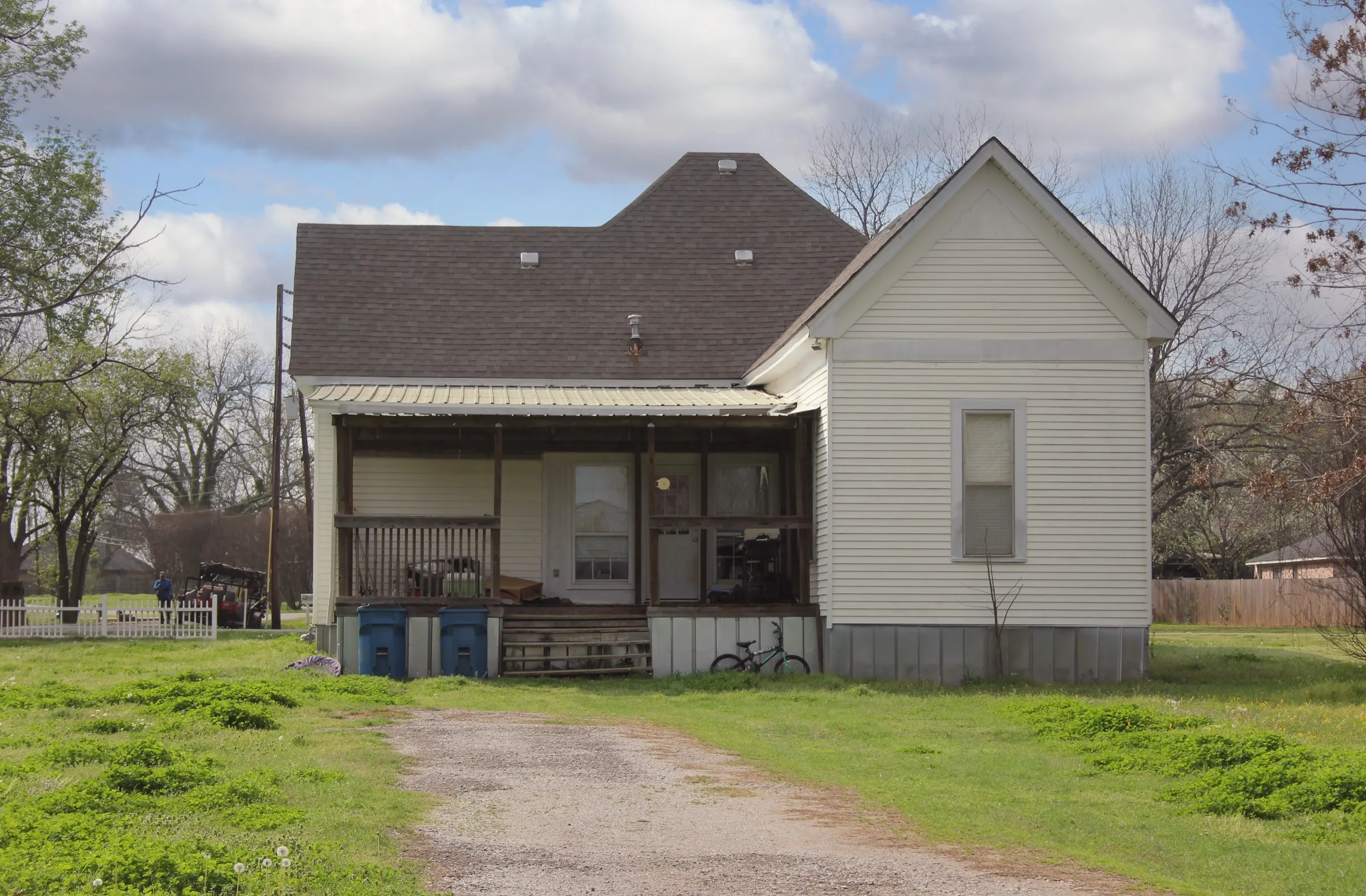Small white farmhouse with a porch in rural East Texas