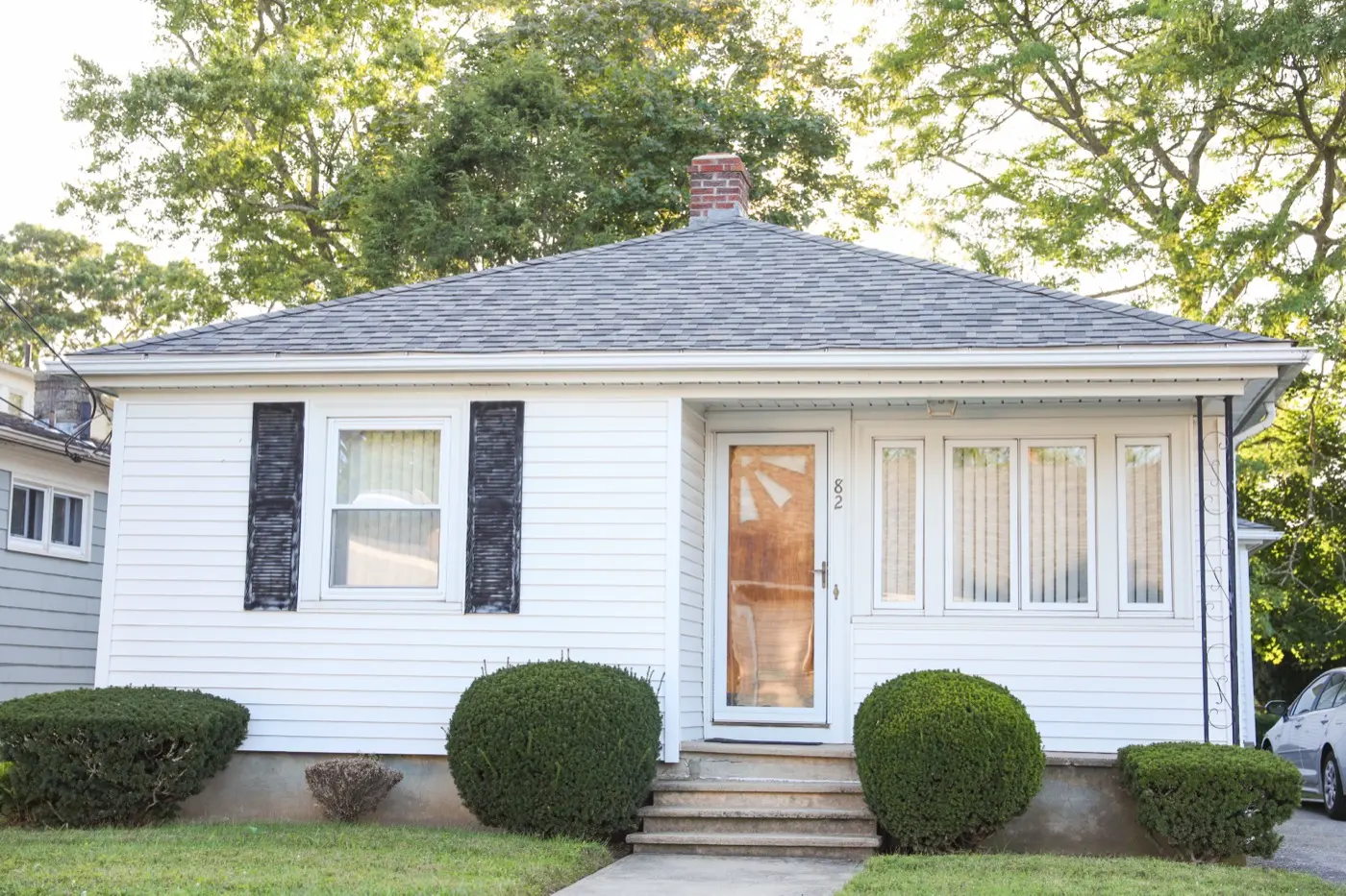 Older white frame bungalow with front steps up to the door