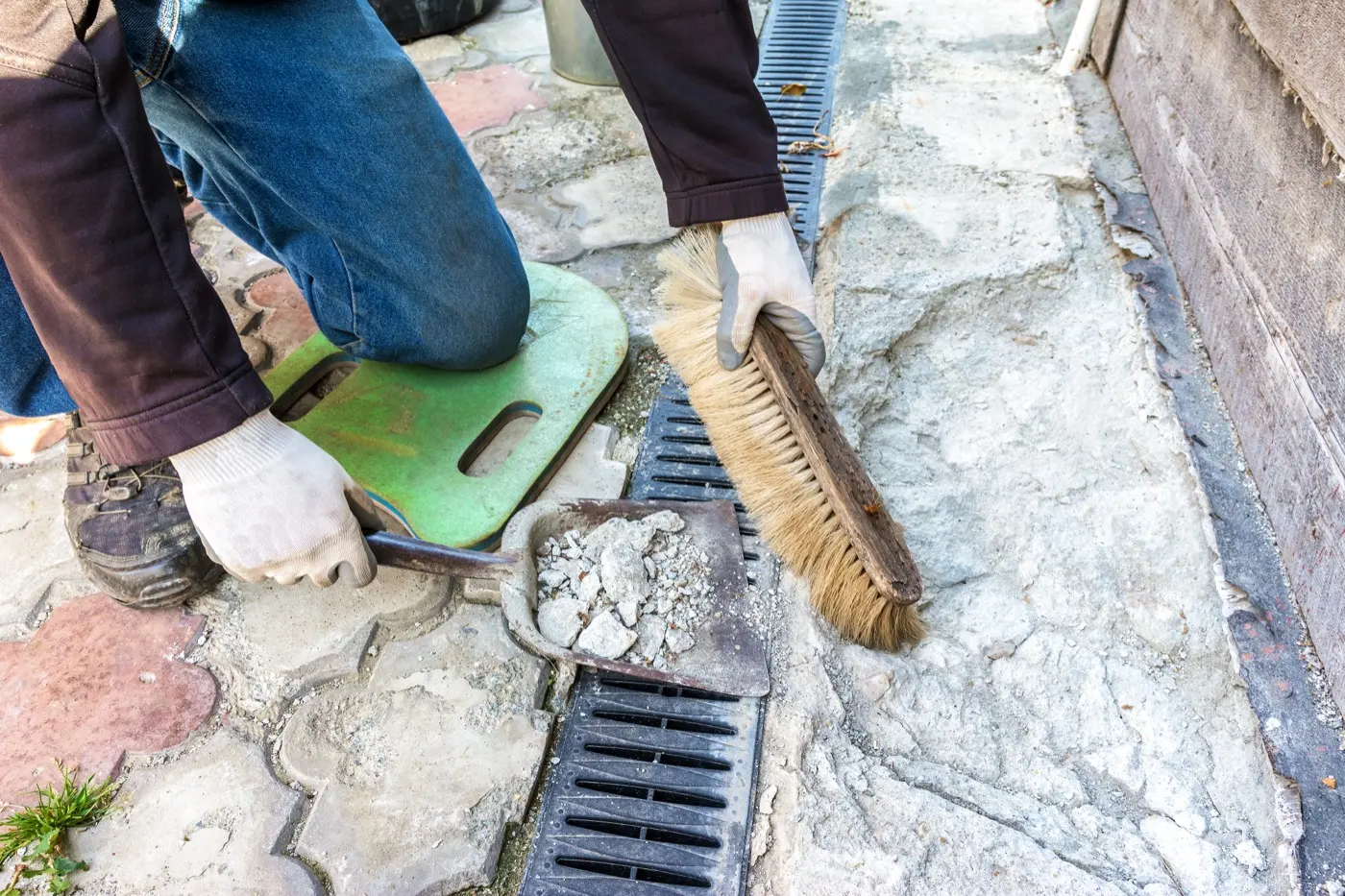 Worker clearing a channel dug along a house foundation